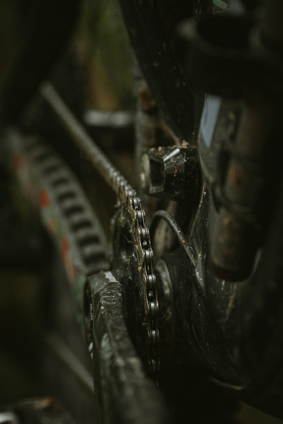 Grime covered bicycle chain and gear mechanism outside.
