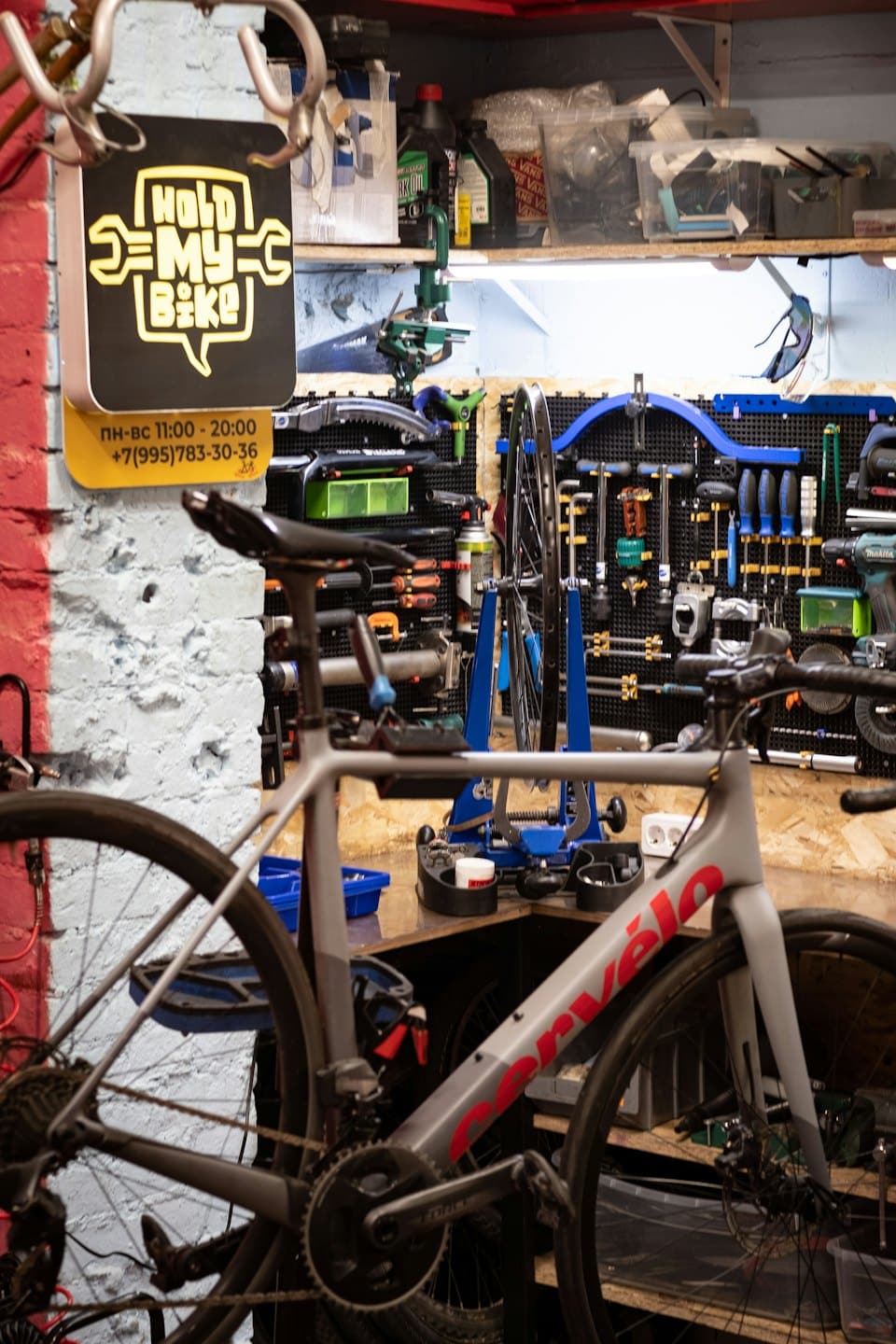 Road bicycle parked in front of a bike repair workshop.